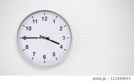 Minimalist White Clock with Silver Frame Striking 15.45/03.45 on White Background. Perfect for Time Management and Corporate Campaigns 121840653
