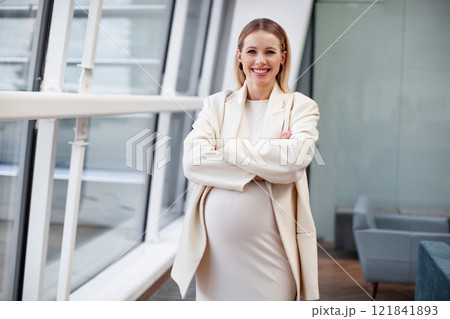 Happy smiling Beautiful confident pregnant blonde woman in stylish and fashionable clothing a white dress and blazer standing, looking at the camera in a corporate office setting Happy smiling Beautiful confident pregnant blonde woman in stylish and fashionable clothing a white dress and blazer standing, looking at the camera in a corporate office setting 121841893