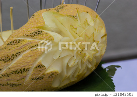 Intricate melon carving showcasing skilled craftsmanship at a culinary event Intricate melon carving showcasing skilled craftsmanship at a culinary event 121842503