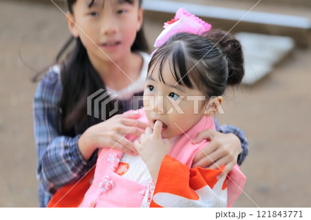 神社に七五三の参拝をする3歳の女の子と9歳の姉 121843771