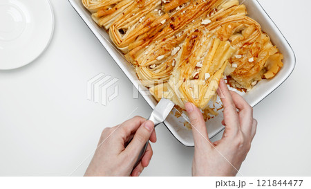 Finished made from phyllo dough Crinkle Cake is cut with a knife 121844477