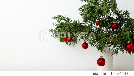 Christmas ornaments creating a festive display, vase with thuja branches 121844480