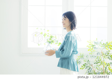 リビングで花瓶を持つ女性 121844972