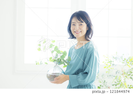 リビングで花瓶を持つ女性 121844974