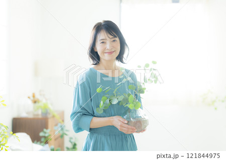 リビングで花瓶を持つ女性 121844975