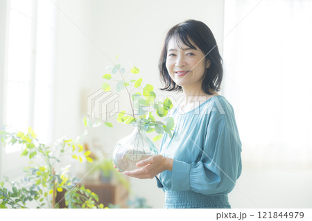 リビングで花瓶を持つ女性 リビングで花瓶を持つ女性 121844979