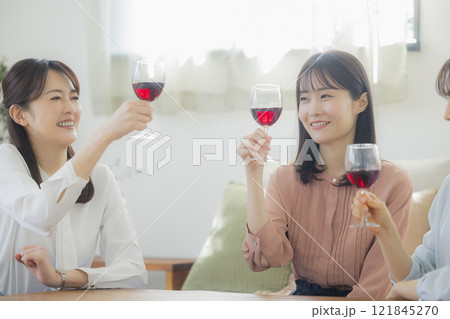 リビングでお酒のグラスを持つ女性 リビングでお酒のグラスを持つ女性 121845270