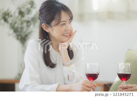 リビングでお酒のグラスを持つ女性 リビングでお酒のグラスを持つ女性 121845271