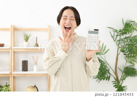 電卓を持って驚く女性 121845433