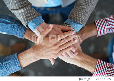 Hands stacked and piled to show team unity, strength and motivation among business men, colleagues and coworkers. Above view, closeup and huddled group of businesspeople in a support and trust circle 121845889