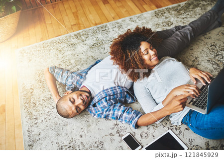 Happy, relaxed and carefree couple bonding together on the living room floor at home. Loving, affectionate and smiling boyfriend and girlfriend relaxing, typing on a laptop and lying down from above Happy, relaxed and carefree couple bonding together on the living room floor at home. Loving, affectionate and smiling boyfriend and girlfriend relaxing, typing on a laptop and lying down from above 121845929