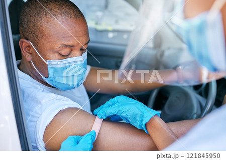 Mobile covid vaccine service outdoors for a patient driving in a car. A healthcare professional applying a plaster on a patient in a vehicle after coronavirus treatment at a vaccination station Mobile covid vaccine service outdoors for a patient driving in a car. A healthcare professional applying a plaster on a patient in a vehicle after coronavirus treatment at a vaccination station 121845950