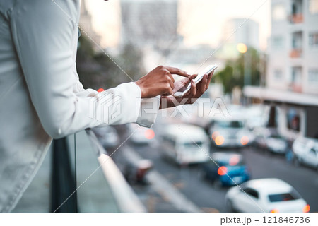 Businessperson texting on their mobile phone to send an email outside on the balcony of a modern office, overlooking a busy city. Corporate professional worker typing outdoors to send a text message Businessperson texting on their mobile phone to send an email outside on the balcony of a modern office, overlooking a busy city. Corporate professional worker typing outdoors to send a text message 121846736