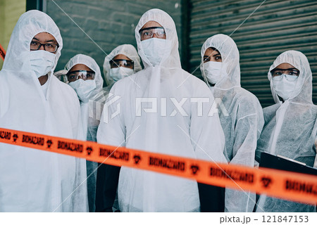 Covid, pandemic and team doctors, scientists or heathcare workers wearing protective ppe to prevent virus spread at a quarantine site. First responders wearing hazmat suits while standing behind tape Covid, pandemic and team doctors, scientists or heathcare workers wearing protective ppe to prevent virus spread at a quarantine site. First responders wearing hazmat suits while standing behind tape 121847153