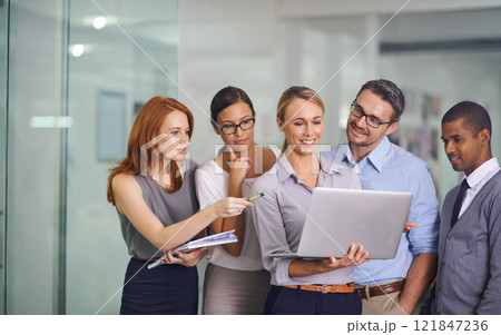 Manager with laptop showing, training or presenting strategy ideas or brainstorm plans with diverse group of office colleagues. Confident, smiling or happy leader updating team of staff on technology 121847236