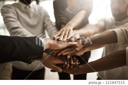 Businesspeople with their hands together in a huddle pile showing support, teamwork and close collaboration at the workplace. Closeup of a diverse group of colleagues standing in unity at the office Businesspeople with their hands together in a huddle pile showing support, teamwork and close collaboration at the workplace. Closeup of a diverse group of colleagues standing in unity at the office 121847315