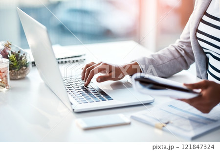 Hands of a female entrepreneur sending emails and doing research on the internet. Businesswoman, secretary and data professional typing on a laptop while analyzing financial reports in her office. Hands of a female entrepreneur sending emails and doing research on the internet. Businesswoman, secretary and data professional typing on a laptop while analyzing financial reports in her office. 121847324
