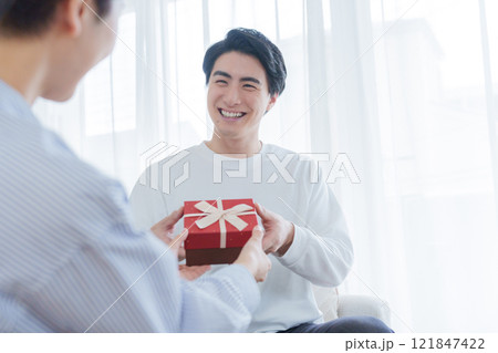 プレゼントをあげる夫婦 121847422