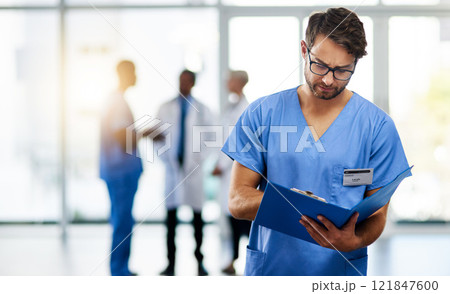 Doctor, healthcare professional and medical worker reading, holding and looking at health information and records in a hospital. Practitioner with a clinic file and colleagues in the background Doctor, healthcare professional and medical worker reading, holding and looking at health information and records in a hospital. Practitioner with a clinic file and colleagues in the background 121847600