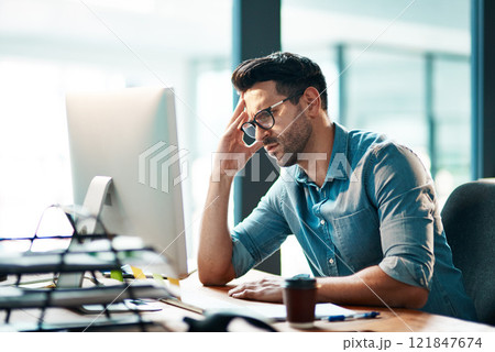 Stress, headache and frustrated business man working on computer in an office, annoyed and anxious. Male under pressure from a workload and deadline. Depressed guy experiencing burnout at work 121847674