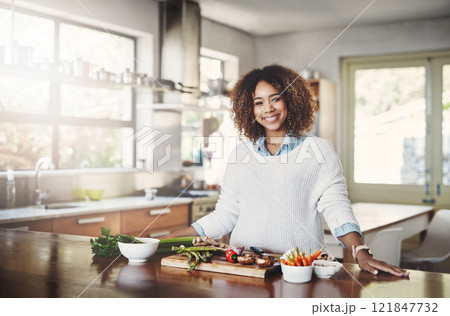 Wellness, cooking and a healthy lifestyle at home with a happy woman starting a weight loss journey. Portrait of a female smiling preparing a nutritious meal with organic vegetables in a kitchen 121847732
