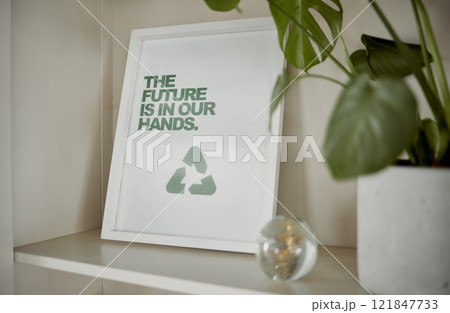 Sustainable, sustainability and recycling sign near a green pot plant. Display of reuse and reduce frame picture on a cupboard of a home or house. The future is eco friendly and clean nature 121847733