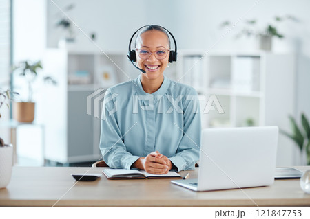 Happy and confident call center agent sitting in front of a laptop while wearing a headset in an office. Portrait of a cheerful saleswoman using web chat to assist customer sales and service support 121847753
