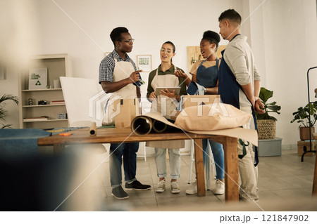 Group of designers doing design teamwork while talking and working on a creative project. A team of diverse fashion studio workers brainstorming. Young staff work together on making clothes 121847902