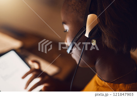 Young student browsing, learning online and searching the web at night on a tablet. Woman watching educational videos with headset, reading from the internet and participating in an online class 121847903
