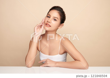 Beautiful young asian woman with clean fresh skin on beige background, Face care, Facial treatment, Cosmetology, beauty and spa, Asian women portrait. Beautiful young asian woman with clean fresh skin on beige background, Face care, Facial treatment, Cosmetology, beauty and spa, Asian women portrait. 121848504