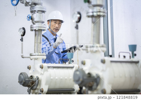 タブレットを持って給水設備の点検をする作業員　ビルメンテナンススタッフ　イメージ　 121848819