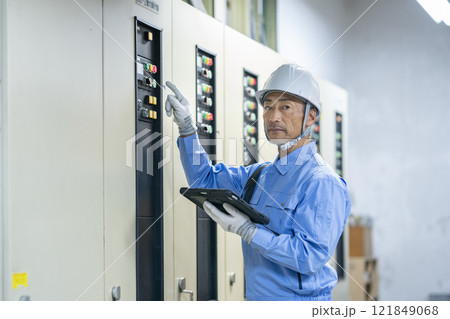 ビルメンテナンススタッフ　イメージ　電気設備の点検をする作業員の横顔 121849068