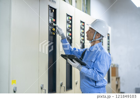 タブレットを持ってビルの電気設備の点検をする作業員　ビルメンテナンススタッフ　イメージ 121849103