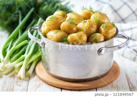 Tasty boiled new potatoes with fresh dill in a wooden table, selective focus. Tasty boiled new potatoes with fresh dill in a wooden table, selective focus. 121849567