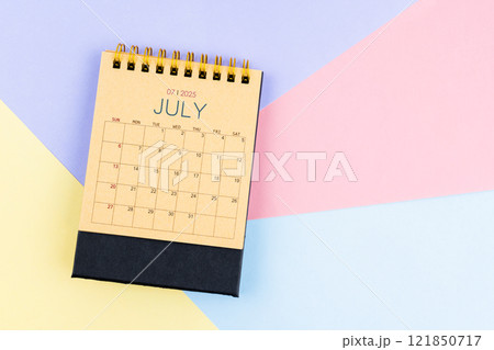 July 2025 desk calendar from brown paper on colorful background. July 2025 desk calendar from brown paper on colorful background. 121850717