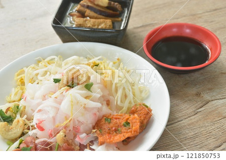 steamed large rice noodles topping slice fried Chinese sausage and crispy pork belly with bean sprout dressing black soy sauce on plate dipping sour soybean sauce 121850753
