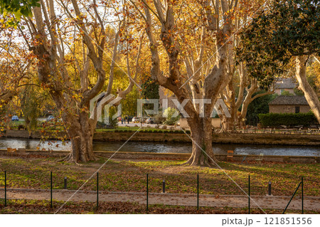 Beautiful autumn park in Provence, France by a calm river. Concept of natural beauty, seasonal charm, and the peaceful allure of the French countryside. 121851556