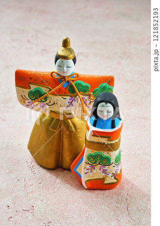 ピンク背景のひな人形（向かって左が男雛、右に女雛）コピースペース有り 121852193