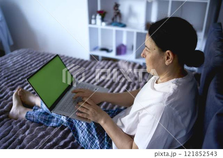 a senior woman working from home on laptop, green screen, chromakey a senior woman working from home on laptop, green screen, chromakey 121852543