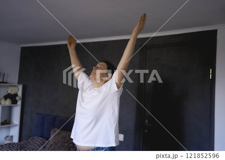 a senior woman performs somatic exercises, yoga at home 121852596