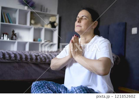 a senior woman performs somatic exercises, yoga at home a senior woman performs somatic exercises, yoga at home 121852602