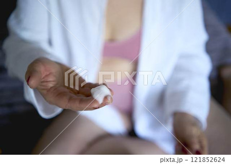 a senior woman in underwear on the bed performs routine self-care with face and body cosmetics, face foam a senior woman in underwear on the bed performs routine self-care with face and body cosmetics, face foam 121852624