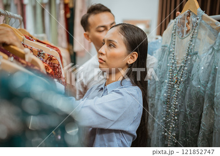 Fashion Shopping Experience Stylish Woman Enthusiastically Browsing Clothes in Boutique Fashion Shopping Experience Stylish Woman Enthusiastically Browsing Clothes in Boutique 121852747