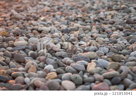 Close-up of smooth pebbles on a beach, bathed in soft evening light Close-up of smooth pebbles on a beach, bathed in soft evening light 121853041