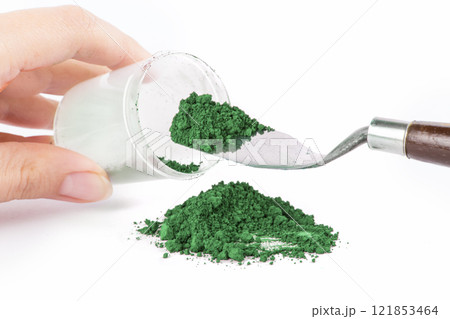 Cobalt Green, Green Powder Spills From a Jar Onto a Clean Surface With a Scoop Nearby Ready for Use 121853464