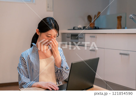 遅くまで在宅勤務をして疲れる一人暮らしの女性 遅くまで在宅勤務をして疲れる一人暮らしの女性 121854590