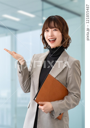 手で案内をする笑顔の女性・ビジネスウーマン 121855487