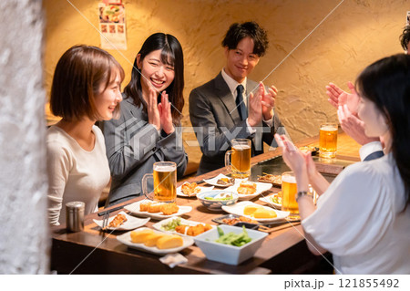 居酒屋で拍手をするビジネスパーソン 居酒屋で拍手をするビジネスパーソン 121855492