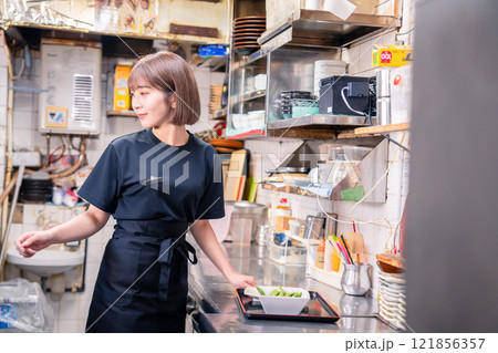居酒屋の厨房で働くキッチンスタッフの女性 居酒屋の厨房で働くキッチンスタッフの女性 121856357