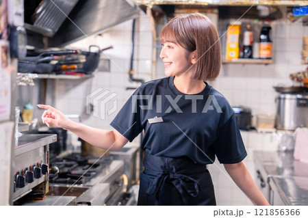 居酒屋の厨房で働くキッチンスタッフの女性 121856366